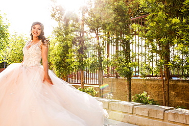 Smiling Hispanic girls wearing gown in park