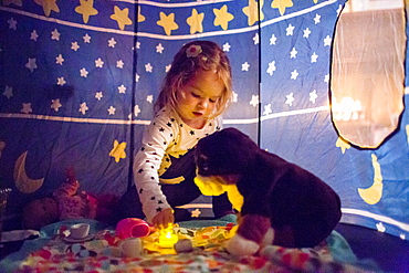 Caucasian girl playing in tent