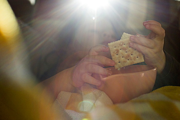 Hands of Caucasian girl eating crackers