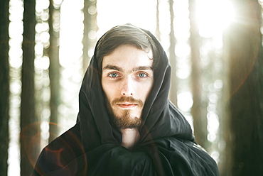 Caucasian man with beard wearing robe in forest