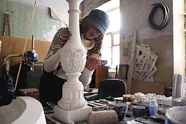 Caucasian sculptor carving plaster piece