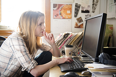 Pensive woman using computer at desk