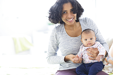 Hispanic mother posing with baby daughter