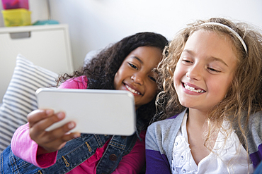 Smiling girls posing for cell phone selfie