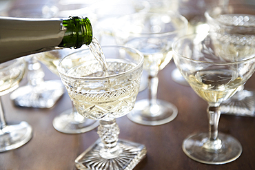 Champagne pouring from bottle into coupe