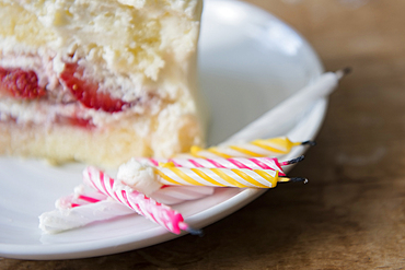 Candles on plate with slice of birthday cake