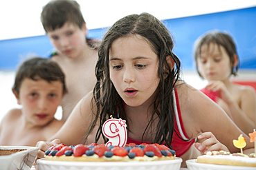 Caucasian girl extinguishing candle on birthday cake