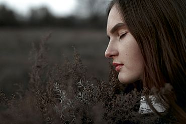 Caucasian woman smelling foliage