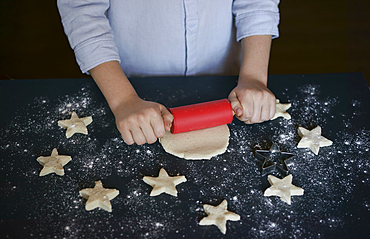 Caucasian boy rolling cookie dough