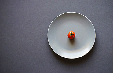 Tomato on white plate