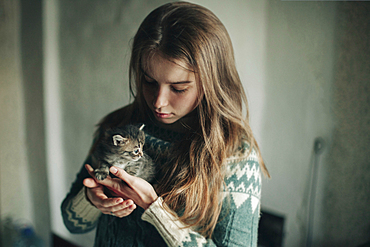 Caucasian woman holding kitten