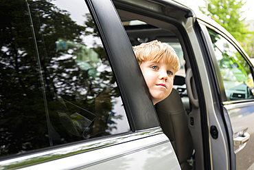 Caucasian boy waiting in mini-van