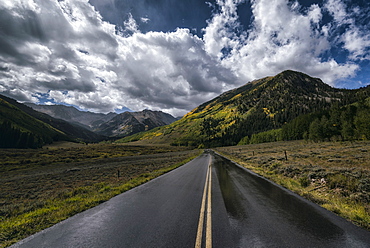 Wet two-lane road near mountains