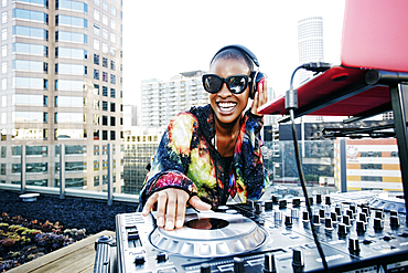 Smiling Black DJ on urban rooftop