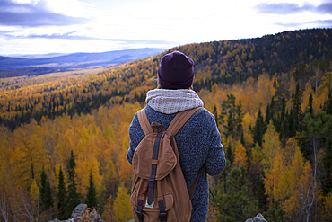 Caucasian woman backpacking in autumn landscape