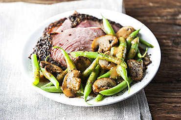 Green beans, mushrooms and ham on plate