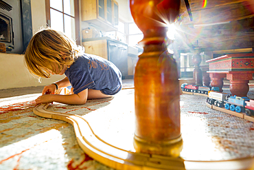 Caucasian boy playing with toy race track on floor