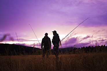 Caucasian men carrying fishing rods