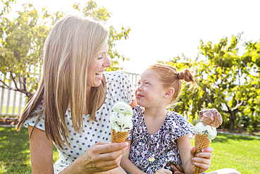 Caucasian mother and daughter eating ice cream cones