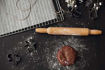 Pastry cutters and gingerbread dough near rolling pin