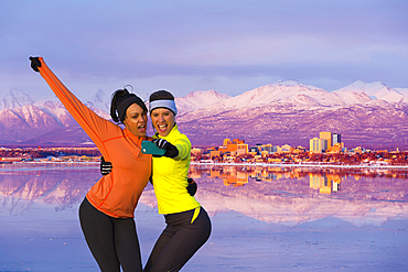 Women posing for cell phone selfie near mountain river