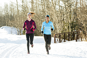 Women running on snow in winter