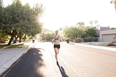 Caucasian woman running in suburban street