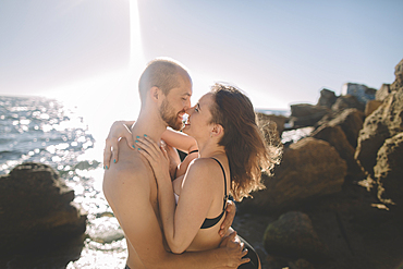 Caucasian couple hugging on beach