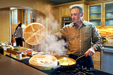 Caucasian man steaming food on stove