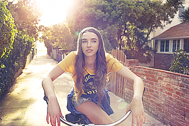 Caucasian woman riding bicycle in alley