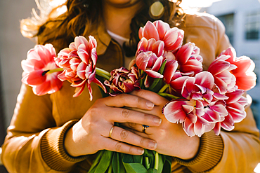 Hands of Mixed Race woman holding flowers