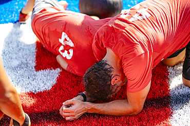 Fatigued men resting on artificial turf field