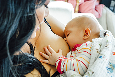 Mother breast-feeding baby daughter