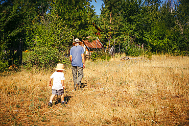 Caucasian grandfather and grandson walking in field