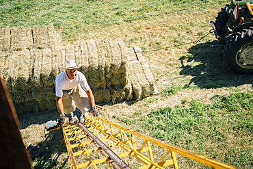 Caucasian farmer climbing ladder to barn