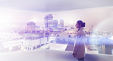 Mixed Race girl admiring cityscape from window