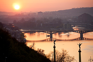 Sunset on bridge over river, Prague, Czech Republic