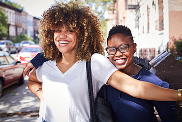 Portrait of Black women hugging on city sidewalk