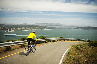 Hispanic man riding bicycle on waterfront road