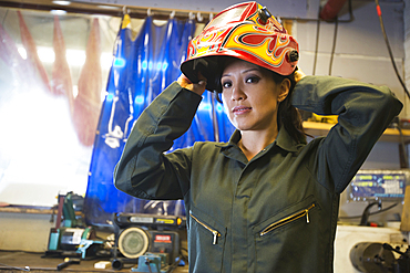 Mixed Race woman wearing protective mask in workshop