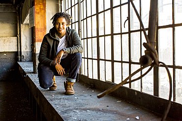 Androgynous Mixed Race woman smiling near window