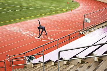 Black woman stretching on track