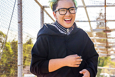 Androgynous Asian woman laughing on footbridge