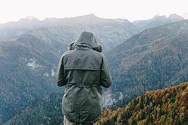 Caucasian man wearing coat looking at valley