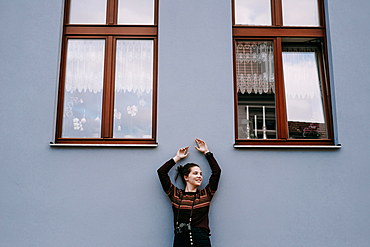 Smiling Caucasian woman leaning on wall