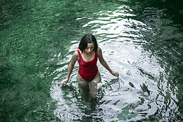 Caucasian woman wading in pool of water