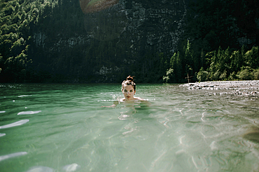 Caucasian woman swimming in mountain lake