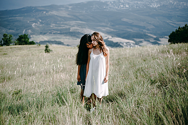 Women standing in field of tall grass