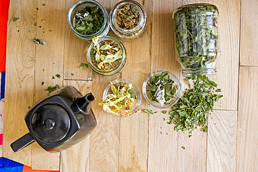 Teapot and tea leaves on table