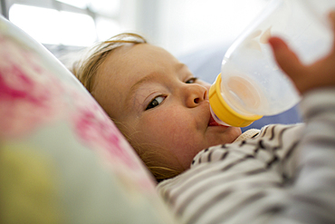 Caucasian baby girl drinking from bottle